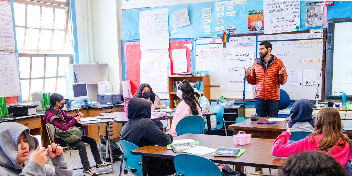 A teacher interacts with their students in a classroom.